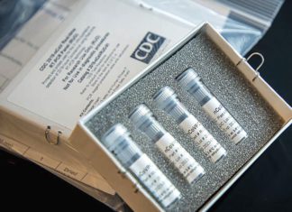 ការពិសោធន៍ប្រើថ្នាំ Remdesivir ដើម្បីព្យាបាលជំងឺ COVID-19 នៅទូទាំងពិភពលោកនឹងចាប់ផ្ដើមនៅខែមីនានេះ រូបថតពីមជ្ឈមណ្ឌលទប់ស្កាត់និងបង្ការជំងឺរបស់សហរដ្ឋអាមេរិកបង្ហាញពីឧបករណ៍សម្រាប់ធ្វើតេស្ដរកមេរោគកូរ៉ូណាវីរុសក្នុងមន្ទីរពិសោធន៍របស់មជ្ឈមណ្ឌលនេះ។